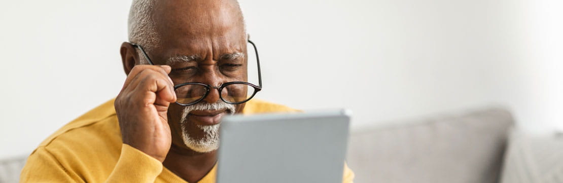 A senior citizen looking at his tablet.